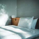 white bed linen beside brown wooden nightstand